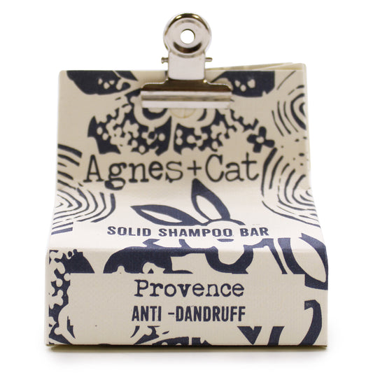 Champú sólido de Provence Agnes + Cat con envoltorio, sobre fondo blanco. Hecho con ingredientes naturales, ideal para un cuidado capilar ecológico y efectivo. Perfecto para quienes buscan una alternativa sin plásticos y respetuosa con el medio ambiente.