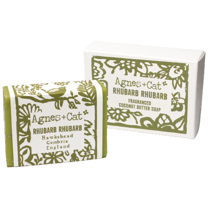 Jabón Artesanal Agnes+Cat Ruibarbo 140g con aroma fresco y dulce, presentado con su caja y envoltorio sobre fondo blanco. Este jabón combina ingredientes naturales y una fragancia única de ruibarbo, ideal para una limpieza suave y aromática.