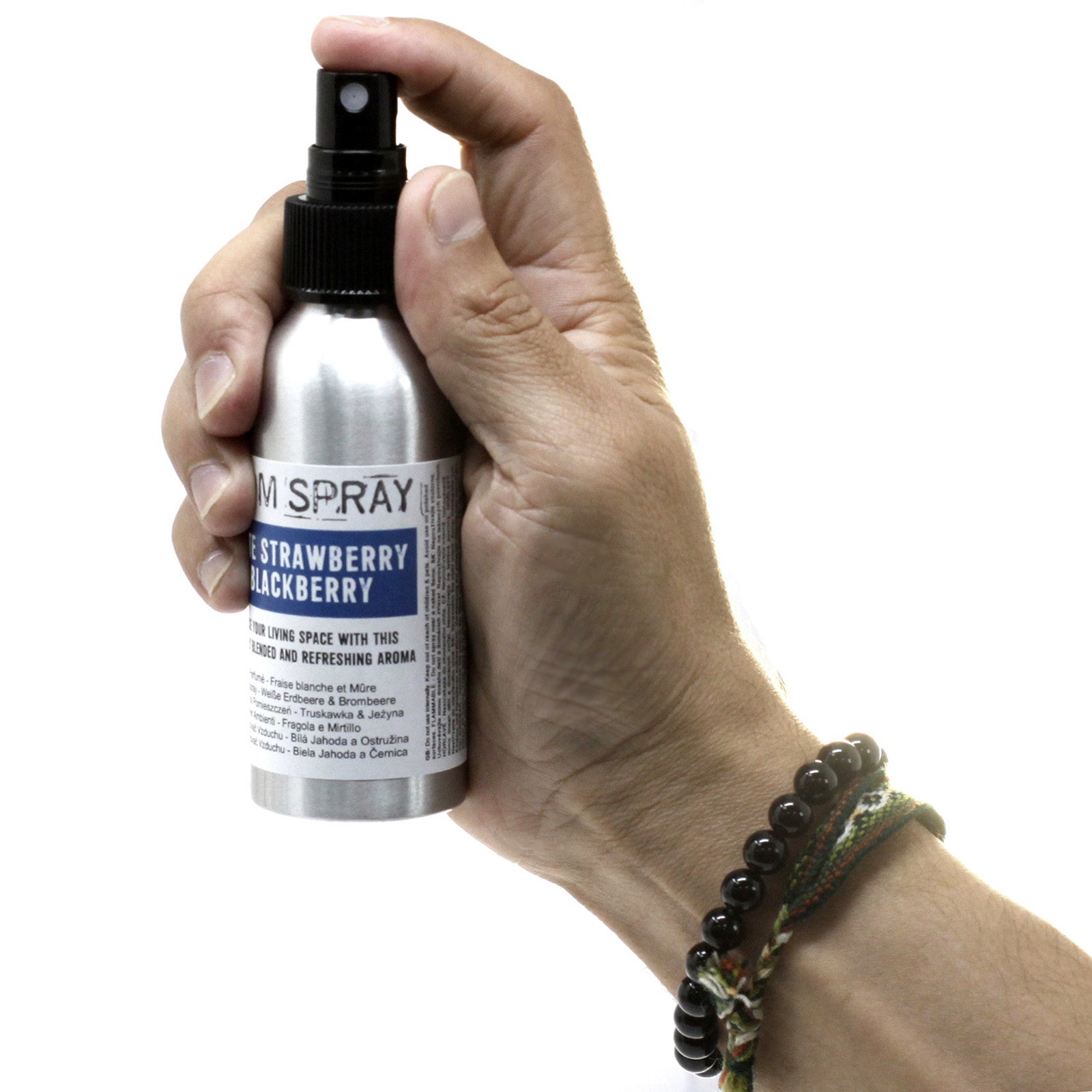 Spray ambiental de Fresa Blanca y Frambuesa de 100 ml sostenido en una mano, perfecto para crear un ambiente dulce y acogedor.