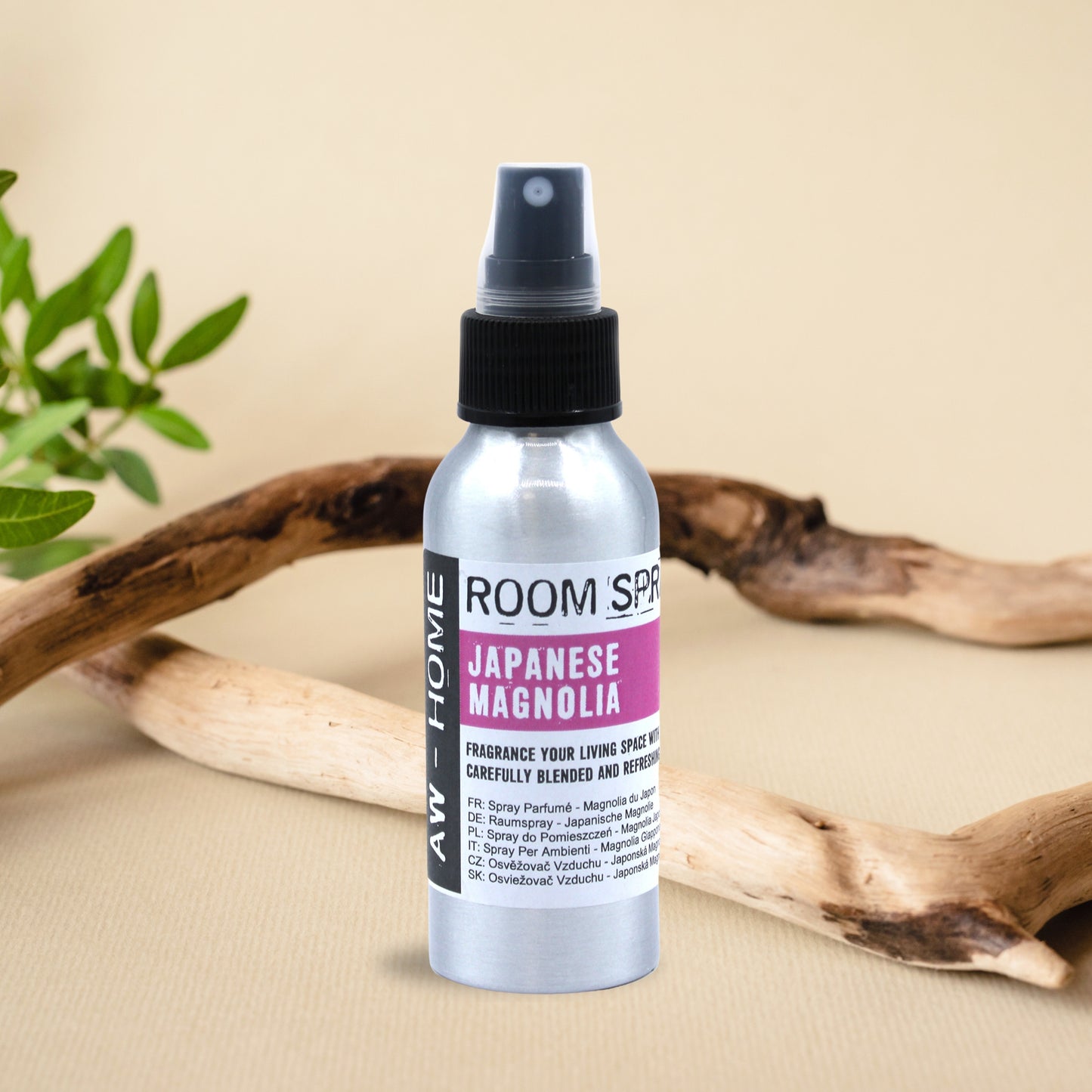 Spray ambiental de Magnolia Japonesa de 100 ml en un frasco de aluminio, sobre una mesa decorada con ramas naturales.