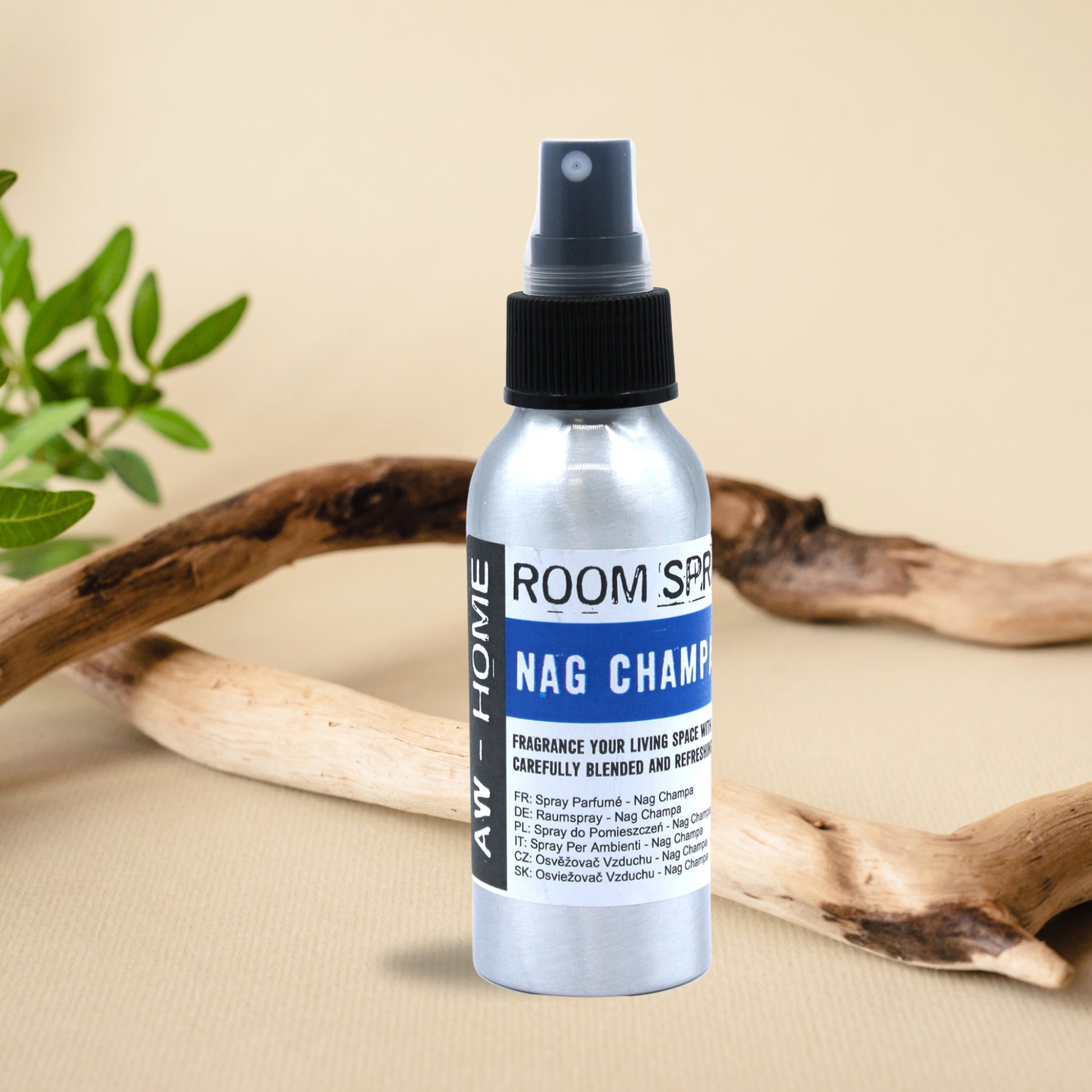 Spray ambiental de Nag Champa de 100 ml en un frasco de aluminio sobre una mesa decorada con ramas naturales.