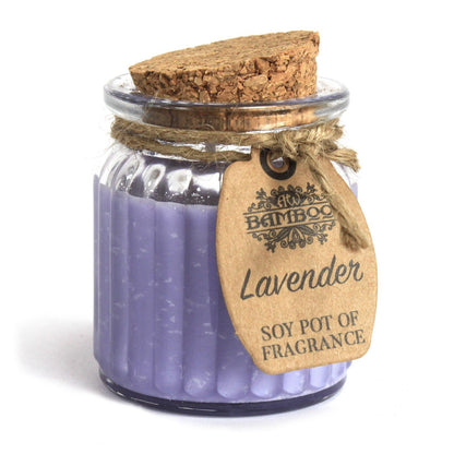 Vela de cera natural con aroma relajante de lavanda sobre fondo blanco, perfecta para crear un ambiente tranquilo y sereno en cualquier espacio.