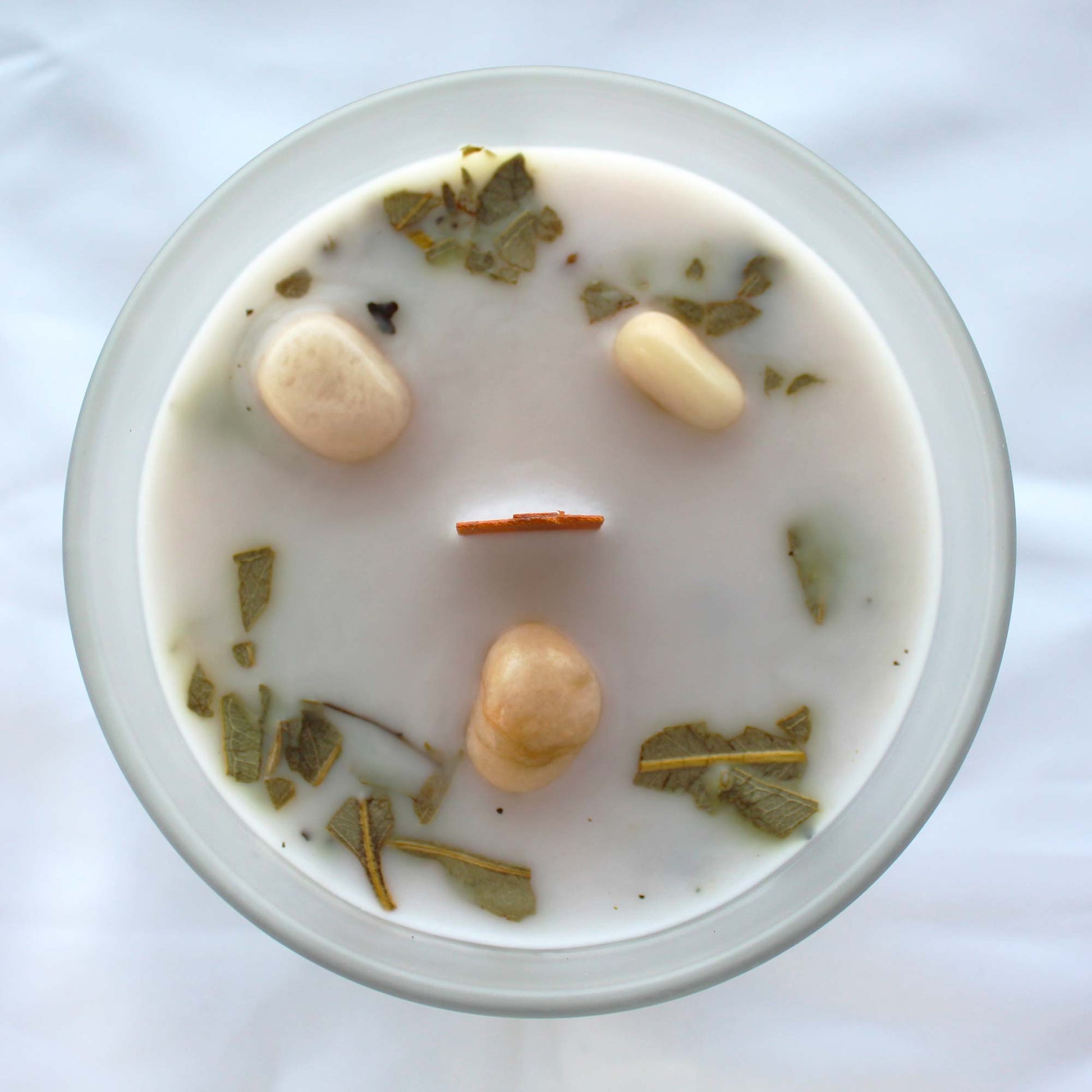 Vela de menta con piedras de la luna abierta, vista desde arriba.